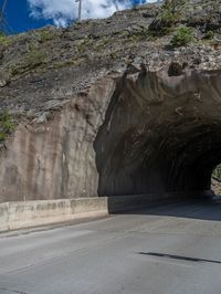 a road goes into a tunnel and through the hill to the other side of it