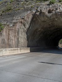 a road goes into a tunnel and through the hill to the other side of it