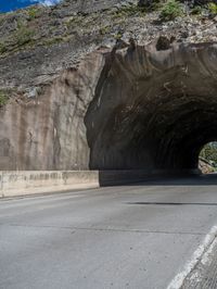 a road goes into a tunnel and through the hill to the other side of it