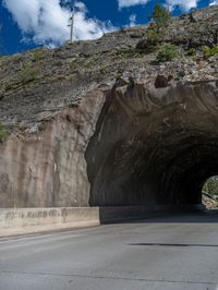 a road goes into a tunnel and through the hill to the other side of it