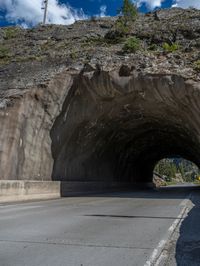 a road goes into a tunnel and through the hill to the other side of it