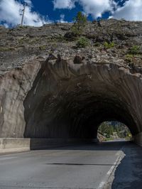 a road goes into a tunnel and through the hill to the other side of it