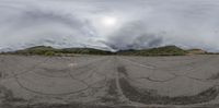 an empty parking lot with mountains in the background and some trees in the foreground