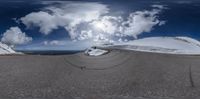 the reflection of a skateboarder on the snowy slope of a mountain, as seen in fish eye