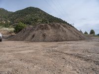 two yellow bulldozers work on sand and gravel in a mountain valley while another one looks at it