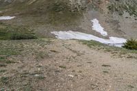 two horses with bags sitting on top of them in the mountains by water and snow