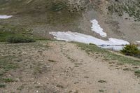 two horses with bags sitting on top of them in the mountains by water and snow