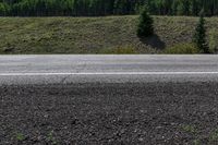 a man stands in the dirt near a road with two white lines on it's side