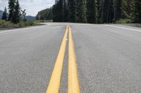 there is a yellow stripe painted on the side of the road that lines the asphalt