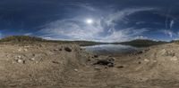 a 360 - vision photograph of a rocky lake by the shore in a mountainous area