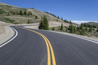 there are two yellow lines on the road near the mountains of canada's west