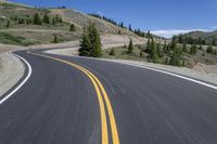 there are two yellow lines on the road near the mountains of canada's west