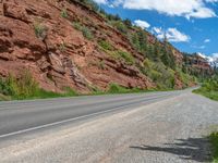 the red rocks are high up on the side of the road and it is an amazing color