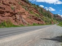 the red rocks are high up on the side of the road and it is an amazing color