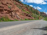 the red rocks are high up on the side of the road and it is an amazing color