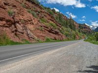 the red rocks are high up on the side of the road and it is an amazing color