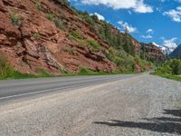 the red rocks are high up on the side of the road and it is an amazing color