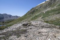 there is a mountain top on the right side and a rock on the left, there is a valley