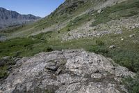 there is a mountain top on the right side and a rock on the left, there is a valley