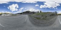 a 360 - view panorama looking out the window on a paved road in mountains, and a mountain view at the top