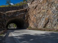 a road goes into a tunnel and through the hill to the other side of it