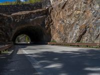 a road goes into a tunnel and through the hill to the other side of it