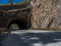 a road goes into a tunnel and through the hill to the other side of it