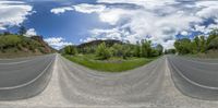 a double lens 360 view of the street in the country side with trees and rocks on both sides