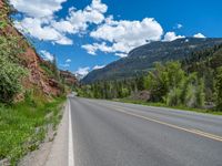 the red rocks are high up on the side of the road and it is an amazing color