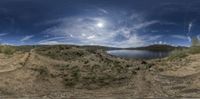 a fish eye view of a lake and mountains from inside a camera lensed car