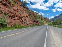 the red rocks are high up on the side of the road and it is an amazing color