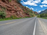 the red rocks are high up on the side of the road and it is an amazing color