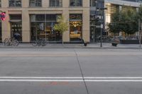 a empty city street next to a big building with tall windows on top of it