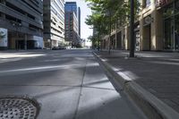 a city street with trees and buildings in the background, the medians on either side are split by two