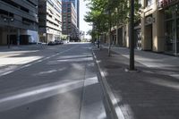 a city street with trees and buildings in the background, the medians on either side are split by two