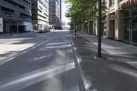 a city street with trees and buildings in the background, the medians on either side are split by two