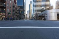 there is an empty street with buildings on both sides of it and people walking on the sidewalks