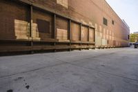the front end of a brick building with empty parking lot next to it in sunlight