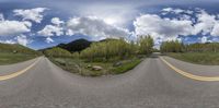 a wide angle image of the empty road, with a big mountain in the distance