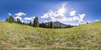 view from the front of a car of a beautiful sunny day in the mountains while driving through a grassy valley