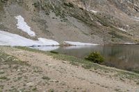 the man with his dog is hiking through the mountains and looks back at the water