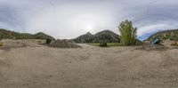 a bunch of construction equipment on a mountain side setting on the ground of a dirt pit