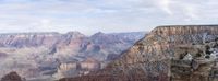 a man is standing at the top of a canyon in the wild overlooking the canyon