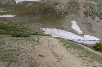 an outdoor area with a road, hill and a snowy field on the side of a mountain