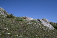 a black frisbee is sitting atop some rocks and boulders on the hillside,