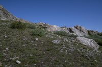 a black frisbee is sitting atop some rocks and boulders on the hillside,