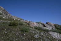 a black frisbee is sitting atop some rocks and boulders on the hillside,