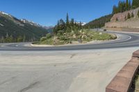 the road looks out into the mountains, with a winding bend along it at least half of which