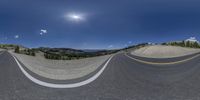 a 360 - view photograph shows a mountain range and road at dusk, with a bright moon above the mountains