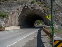 a road goes into a tunnel and through the hill to the other side of it